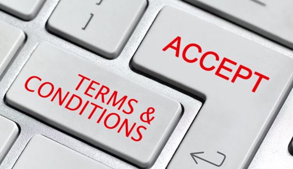 Closeup for a laptop keyboard with "Terms & Conditions" and "Accept" written in red on two of the keys.